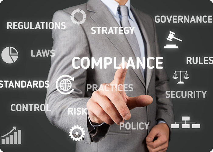 A man in a suit pointing to the word compliance.