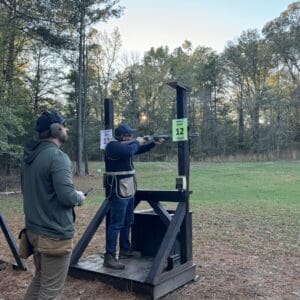 Two people at an outdoor shooting range.