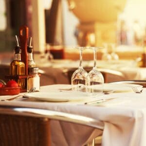 Sunlit bistro table with inverted wine glasses