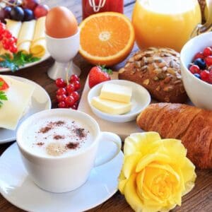 Croissant and cappuccino with fresh fruit breakfast