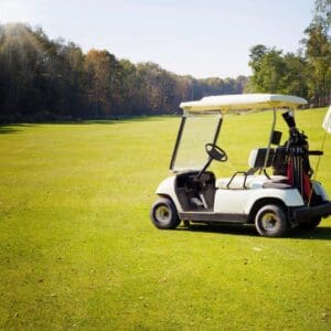 White golf cart parked on sunny fairway