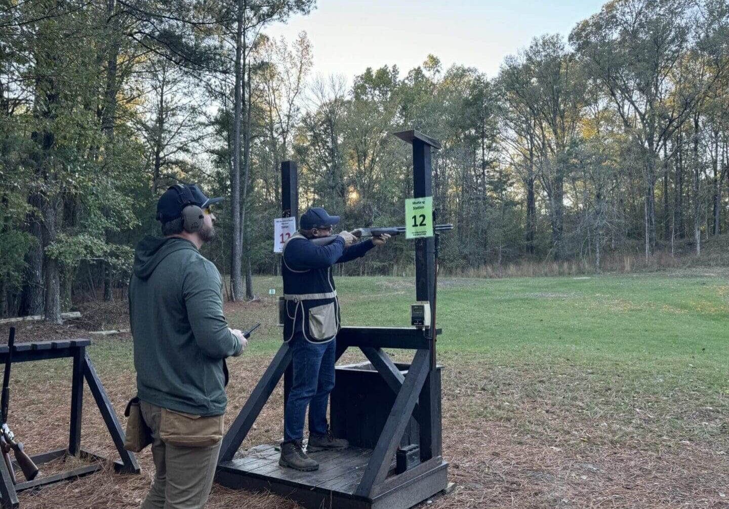Two people at an outdoor shooting range.